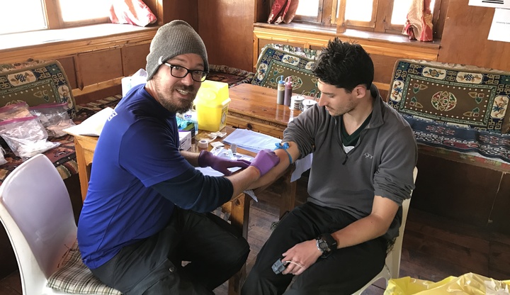 Eric takes blood from one of the research participants